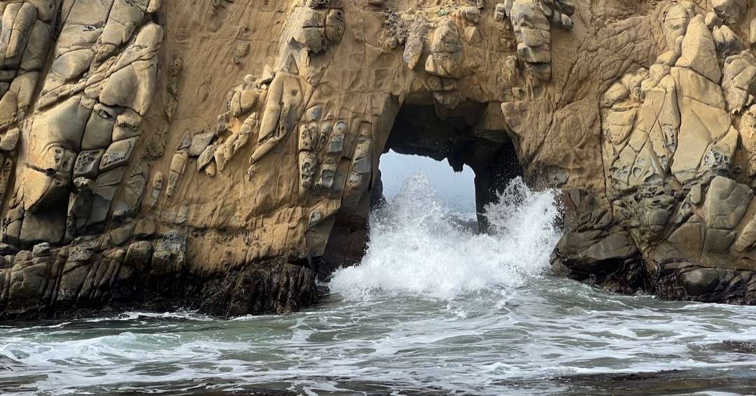 Crashing surf through rock arch